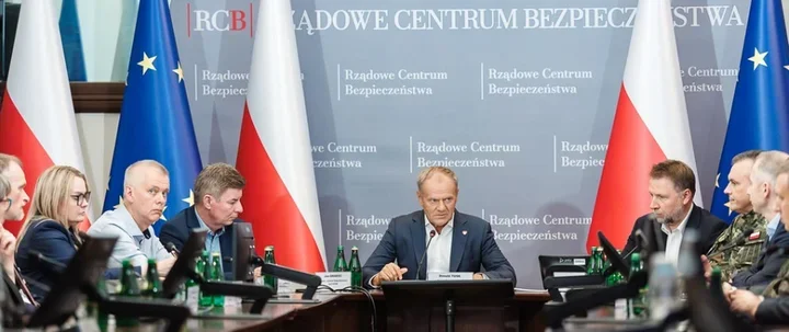 Spotkanie w siedzibie Rządowego Centrum Bezpieczeństwa przy owalnym stole z udziałem polityków, wojskowych i urzędników.